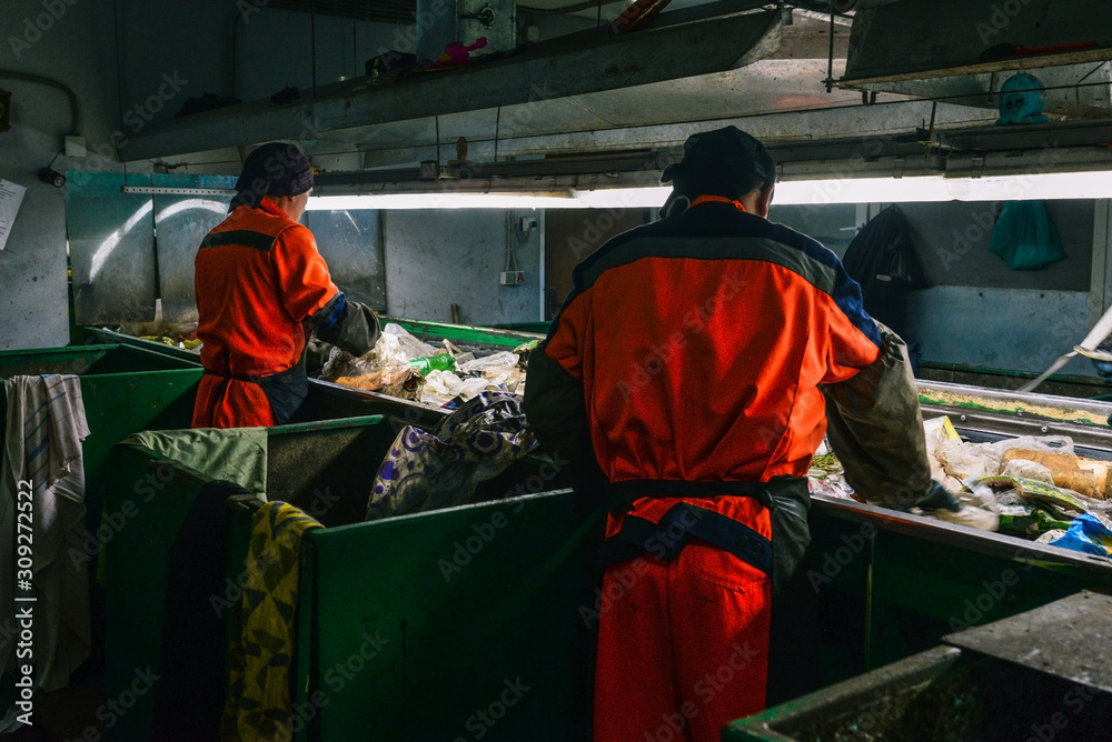 Worker at a waste processing plant. A man sorts rubbish with his hands. Sorting tape. The business of sorting and recycling