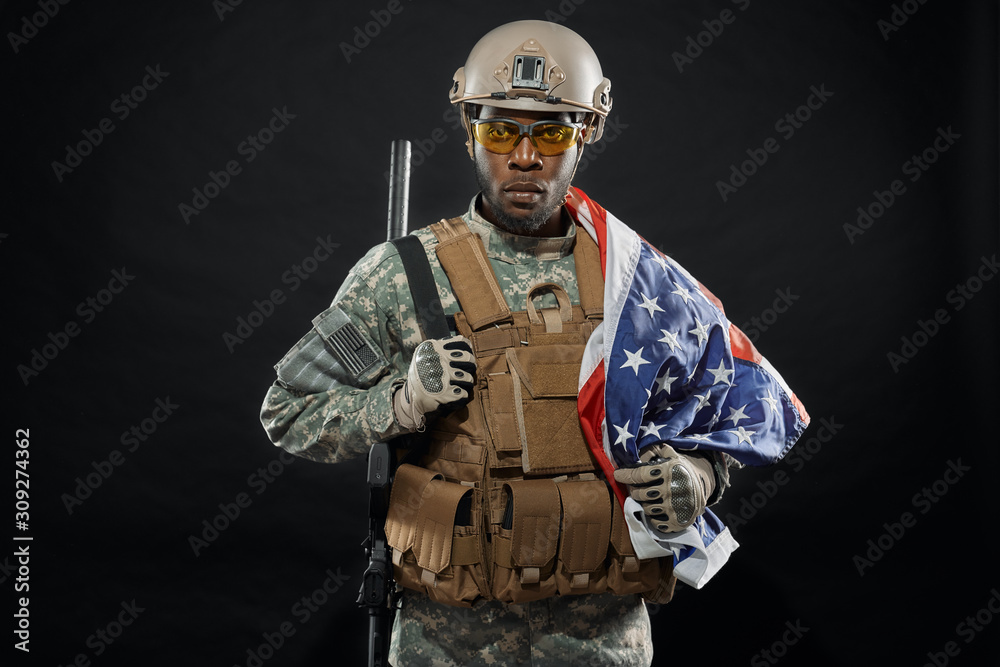 Brave African soldier posing with national flag on shoulder. Brave African soldier posing with national flag on shoulder.