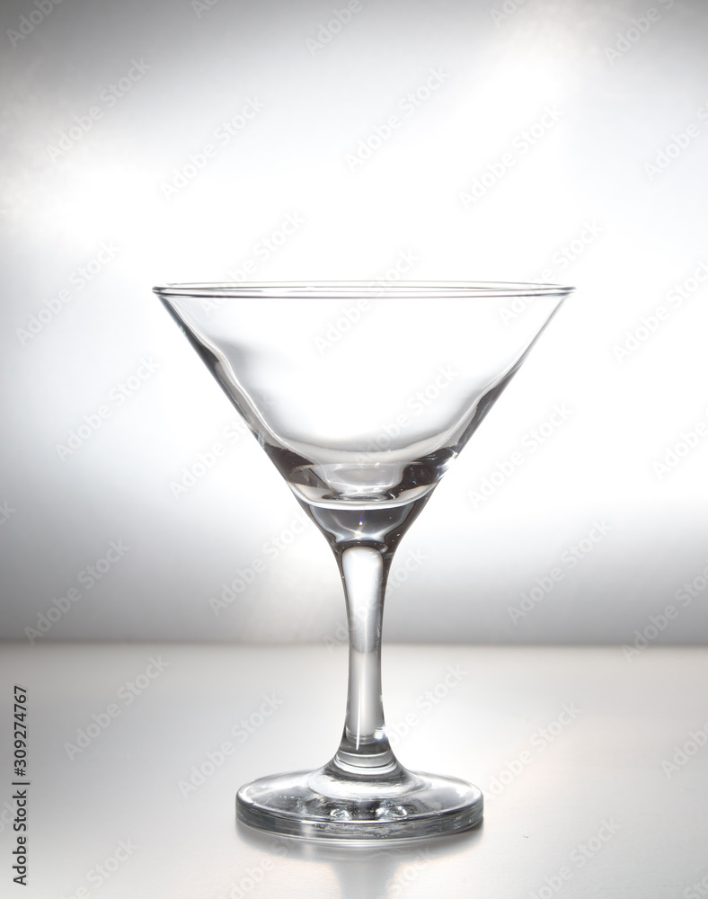 Empty martini glass, cocktail glass isolated with grey background Empty martini glass, cocktail glass isolated with grey background