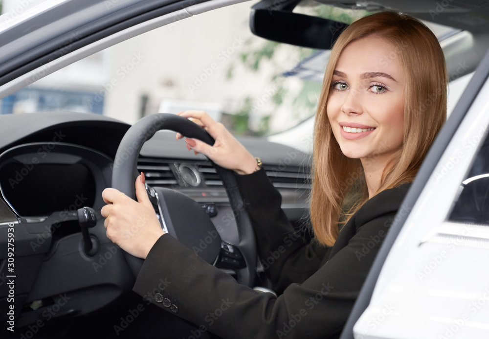 Naklejka premium Female customer of auto salon sitting in white car