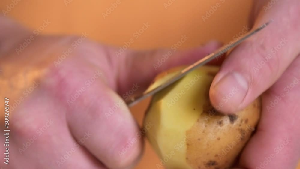 Closeup peeling potatoes with dull knife Closeup peeling potatoes with dull knife