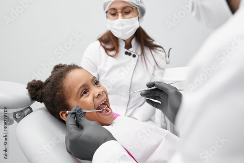 Funny girl lying on dentist chair with open mouth