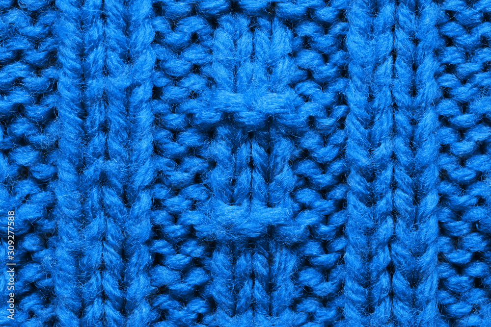 The texture of a knitted sweater. Blue pattern. Facial surface. Background. Copy space The texture of a knitted sweater. Blue pattern. Facial surface. Background. Copy space