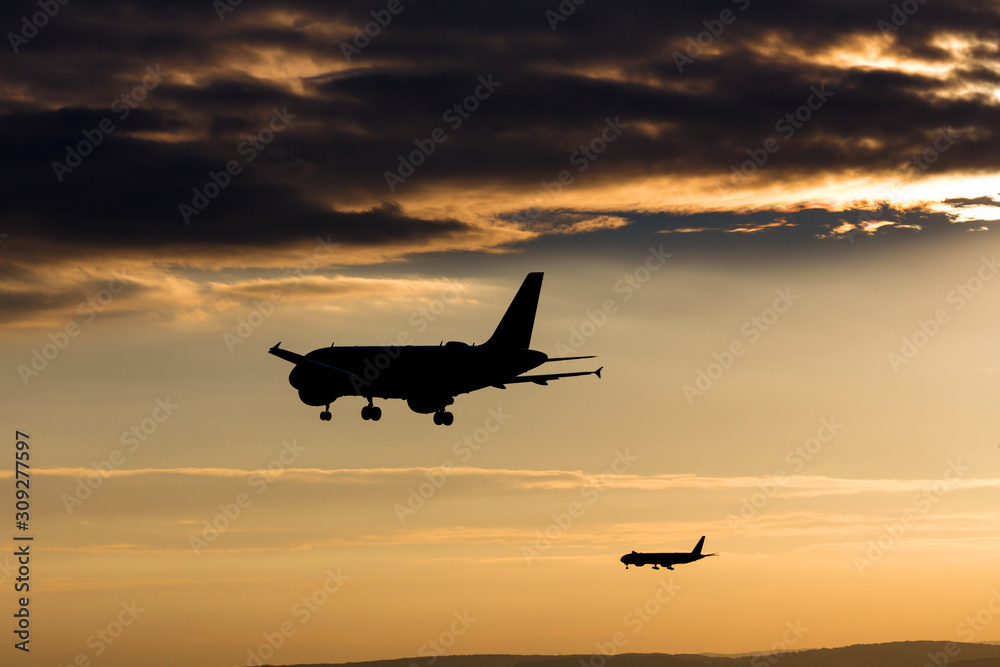 passenger airplanes landing in the evening sun