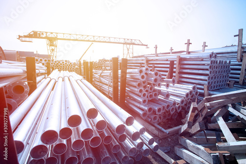 Metal warehouse outdoor of lighting poles. Storage of metal galvanized faceted pipes with flange.