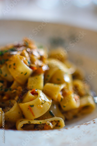 detail of plate of calamari with paccheri with red tuna, cooked with celery, carrots, onion and Taggiasca olives, in a refined Italian restaurant photo