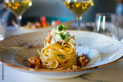 haute cuisine dish with spaghetti with lobster, buffalo stracciatella and a fine white wine. In a luxurious Italian restaurant