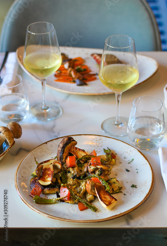 table for two in a luxury Italian restaurant  dishes with roasted eggplant  candied pumpkin  marinated scapece courgette  fried fry of Penta di Frisciano  saut  ed porcini mushrooms and sage