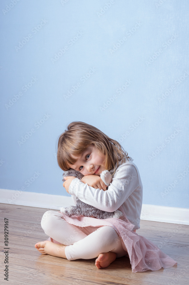 Girl gives cuddles to her fluffy toy kitten Girl gives cuddles to her fluffy toy kitten