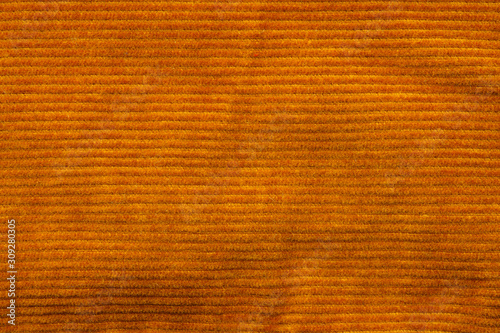Texture of corduroy velvet fabric close-up. Texture of rufous velvet clothes. Textile fabric as background photo