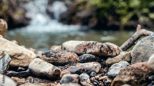 Small stones and pebbles on the river coast. Selective focus, shallow depth of field.