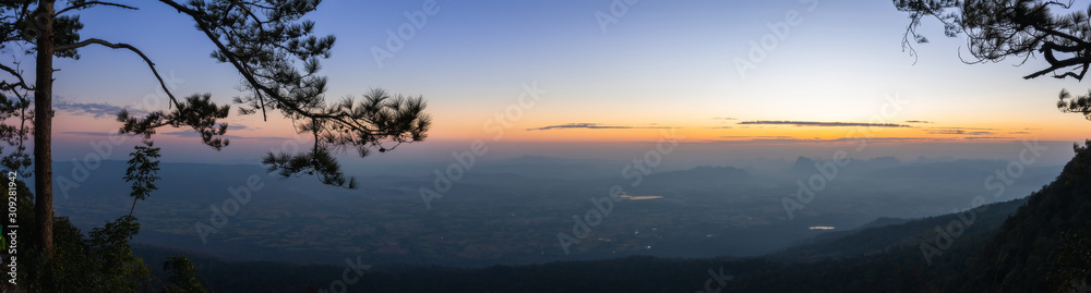 Beautiful sunrise landscape at the top of mountain. Nok An cliff in the morning panorama with twilight sky at Phu Kradueng National Park, Loei, Thailand.