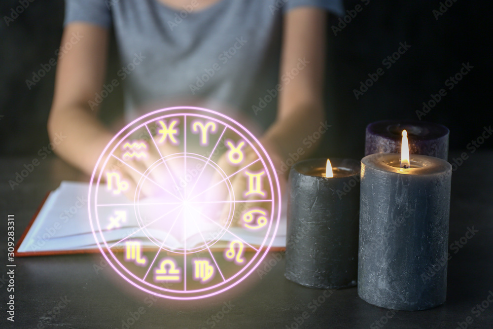 Fototapeta premium Burning candles on table of female astrologist