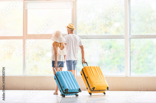 Couple with suitcases at th...