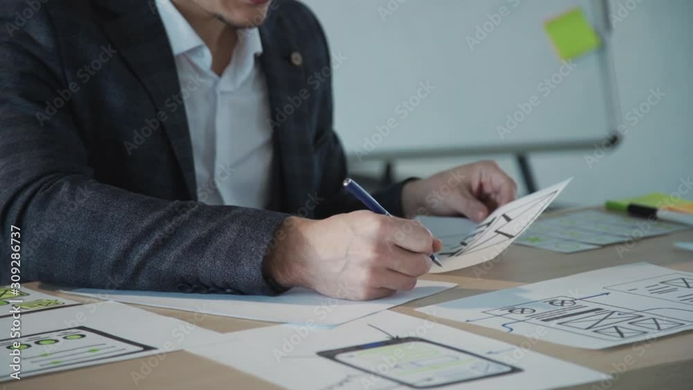 Concept create ux design for people. Creative male employee working on new project and taking notes. man architect designer working drawing on paper sitting at desk in office. slow motion. Concept create ux design for people. Creative male employee working on new project and taking notes. man architect designer working drawing on paper sitting at desk in office. slow motion.