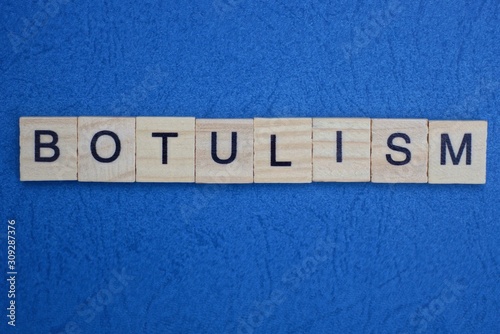 word botulism made from wooden gray letters lies on a blue background photo