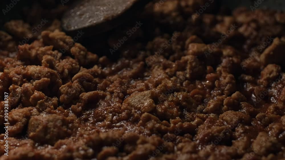 Pan from a pot of freshly made Bolognese sauce to a pot full of boiling water and pasta noodles.