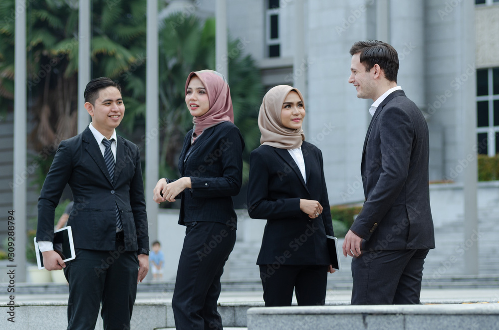 Group of young executive people in formalwear discussing something and gesturing Group of young executive people in formalwear discussing something and gesturing