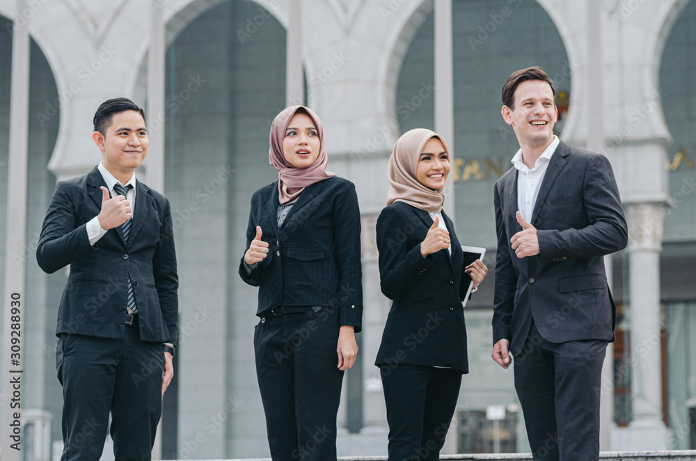 Group of young executive people in formalwear holding tablet and discussing something.happy face expression Group of young executive people in formalwear holding tablet and discussing something.happy face expression