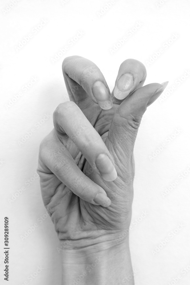 Female hand with long nails. Black and white photo. Crooked fingers on the hand. Female hand with long nails. Black and white photo. Crooked fingers on the hand.