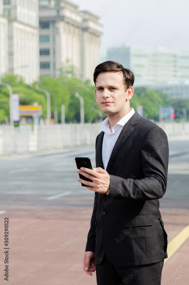 Portrait of young businessman Texting to Someone on his Mobile Phone with Happy Facial Expression. Portrait of young businessman Texting to Someone on his Mobile Phone with Happy Facial Expression.