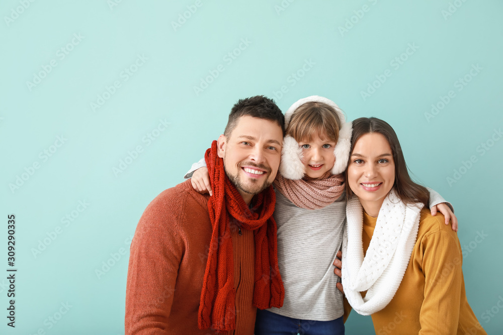 Happy family in winter clothes on color background Happy family in winter clothes on color background