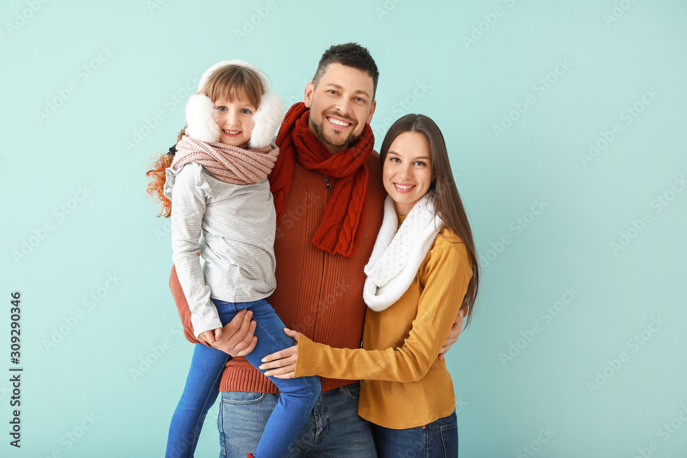 Happy family in winter clothes on color background Happy family in winter clothes on color background