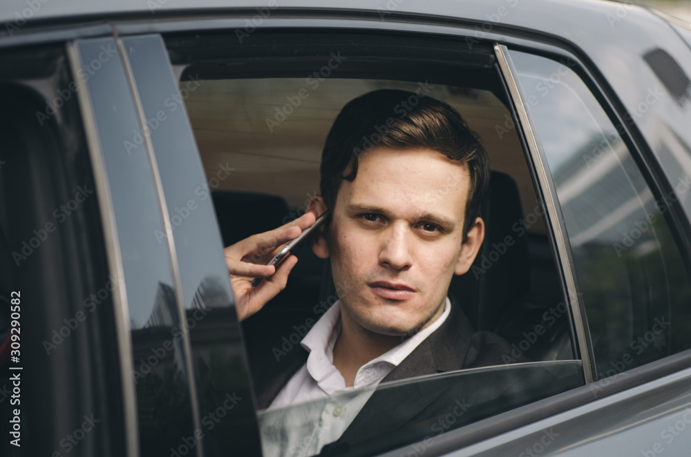 Portrait of young businessman talking to Someone on his Mobile Phone with serious Facial Expression.