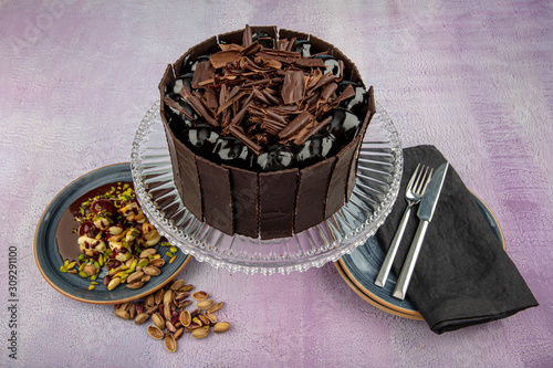 Profiterole layered chocolate cake. Chocolate cake with mascarpone on rpink background. Freshly made delicious chocolate cake. photo