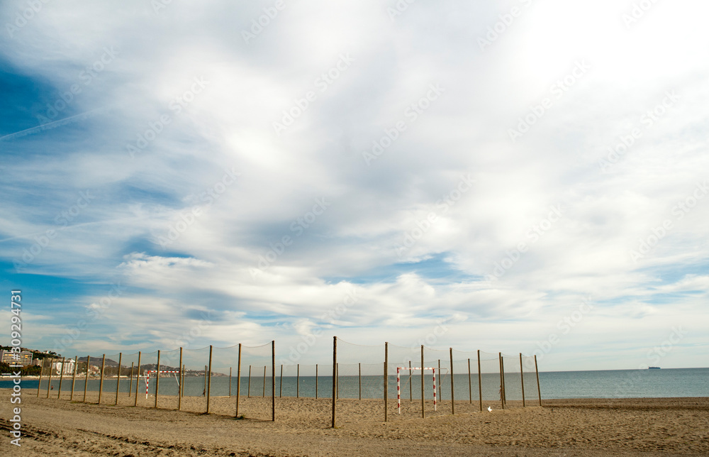 beautiful photo of malaga city beach, with soccer field in the sand, with wooden fence protection and ropes