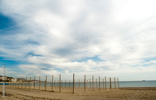 beautiful photo of malaga city beach  with soccer field in the sand  with wooden fence protection and ropes