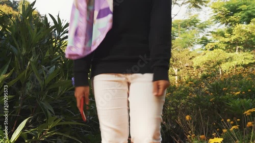 Attractive young Muslim woman enjoying view of green park with beautiful flowers at Cameron Highlands, Pahang
