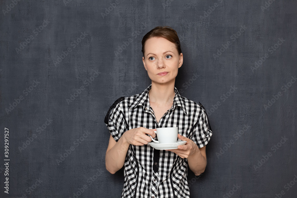 Portrait of sad dreamy young woman holding white cup with tea in hands Portrait of sad dreamy young woman holding white cup with tea in hands