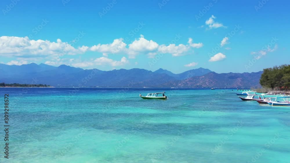 Tranquil turquoise lagoon with clear crystal water where boats floating near shore of tropical island full of holiday resorts in Indonesia Tranquil turquoise lagoon with clear crystal water where boats floating near shore of tropical island full of holiday resorts in Indonesia
