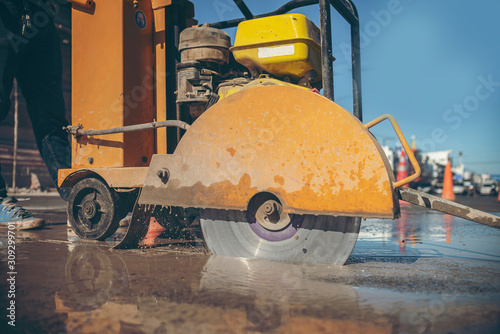 Bilde på lerret cutting concrete floor with worker cutting concrete road with diamond saw blade
