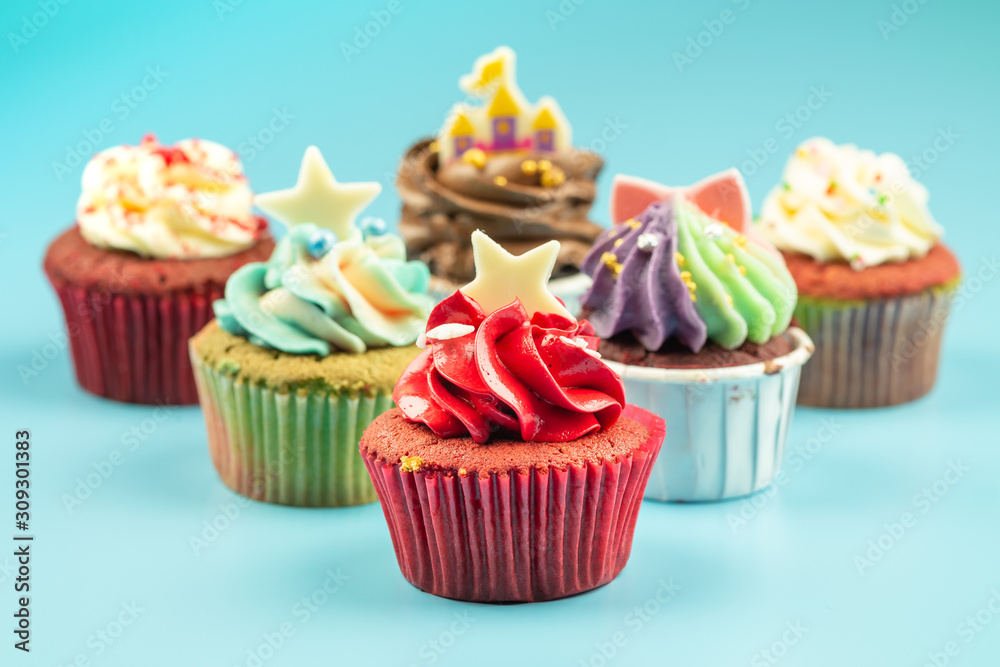 Many sweet colored cupcakes for birthdays, Merry Christmas and New Year 2020 on a blue background.