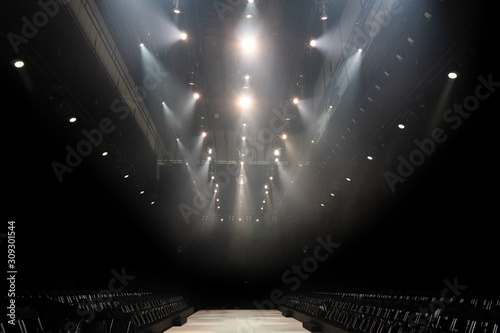 Performance moving lighting luminous rays on construction rack light beam ray downward in white red color, on Concert and Fashion Show stage ramp, intention add grain noise photo