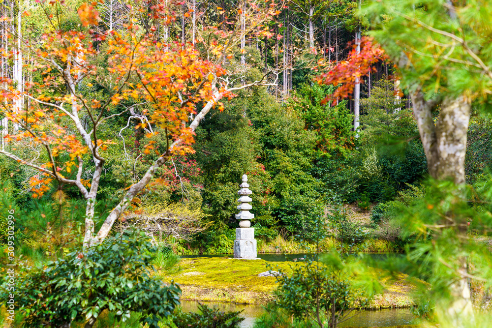 紅葉するモミジと石塔
