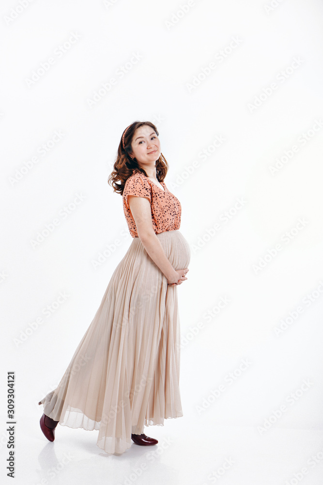 pregnant woman stroking her belly on white background. Copy space. The concept of healthy digestion, lifestyle, IVF pregnant woman stroking her belly on white background. Copy space. The concept of healthy digestion, lifestyle, IVF