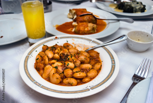 A traditional greek dish Fasolia - Giant beans on a tavern table, outdoors. photo