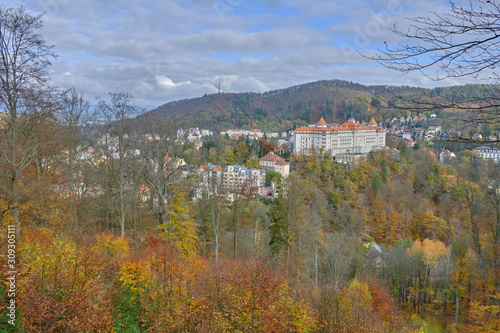Scenic aerial view of Karlovy Vary - small ancient touristic resort town near the border between Czech Republic and Germany. Beautiful summer sunny look of little famous town among hills in Czechia