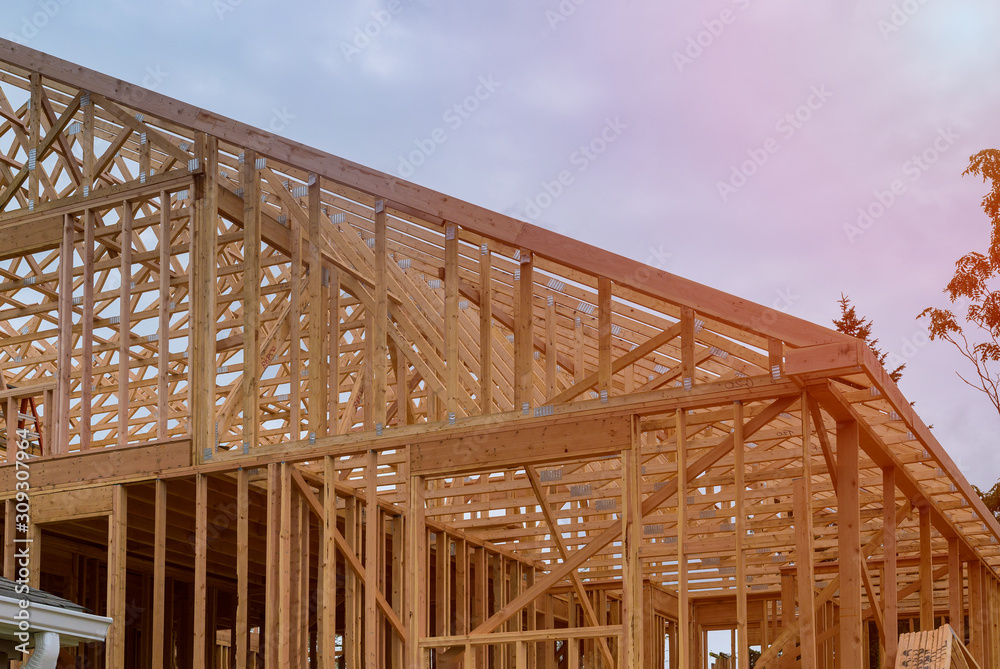 Obraz premium New construction home framing against a blue sky