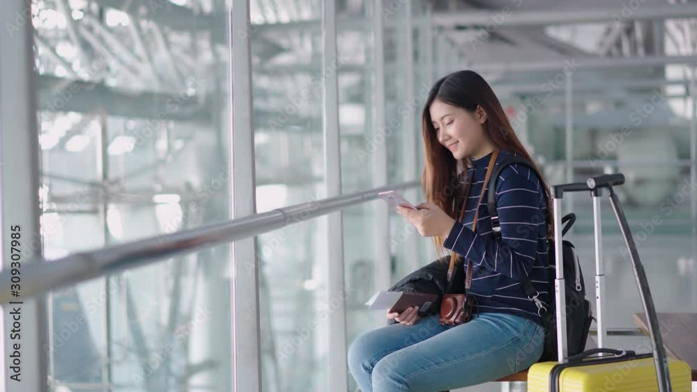 Young traveler woman use smartphone while waiting at airport Young traveler woman use smartphone while waiting at airport