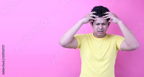 Portrait of a  handsome ,Asia man with a headache on pink background in studio With copy space.