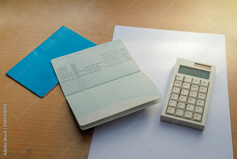 passbooks saving account, calculator with note on wood background passbooks saving account, calculator with note on wood background
