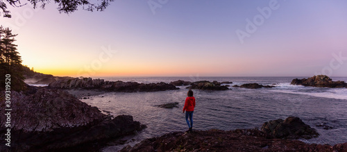 Adventurous Girl Enjoyin the Beautiful View of the Rocky Ocean Coast during a colorful and vibrant morning sunrise. Taken in Ucluelet, near Tofino, Vancouver Island, BC, Canada.