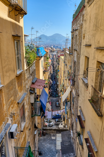 Narrow alleyway in the old town of Naples with Mount Vesuvius in the back photo
