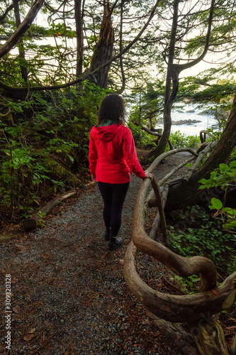 Adventurous Girl walking in a Forest with a beautiful view on the Ocean Coast during a vibrant colorful sunrise. Wild Pacifc Trail, Ucluelet, Vancouver Island, BC, Canada.