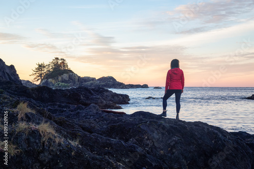 Wild Pacifc Trail  Ucluelet  Vancouver Island  BC  Canada. Girl Enjoyin the Beautiful View of the Rocky Ocean Coast during a colorful and vibrant morning sunrise.