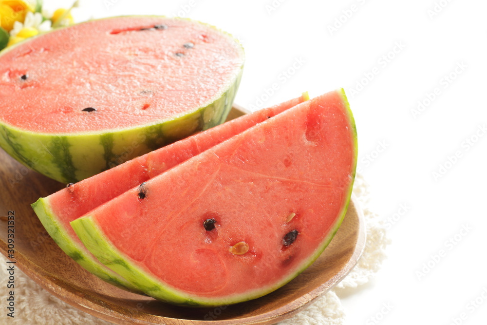 sliced watermelon on wooden plate on white background with copy space